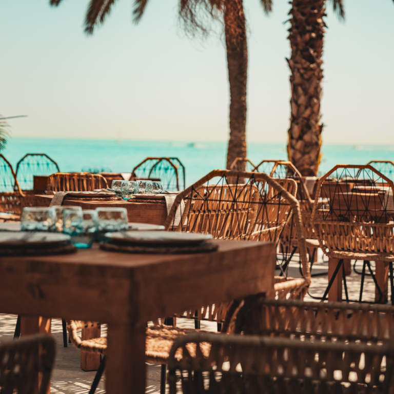 Terraza de Kanaloa Marbella con mesas, palmeras y vistas al mar Mediterráneo
